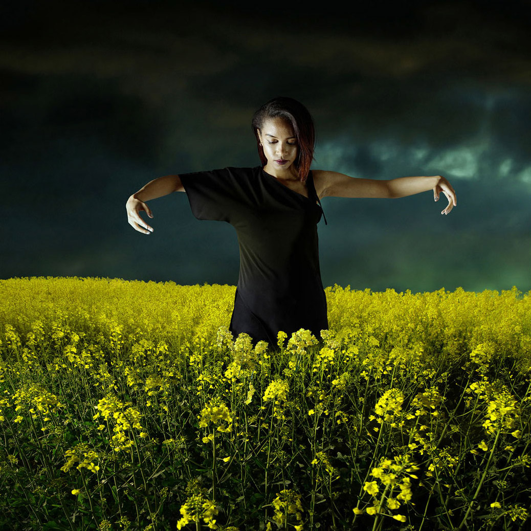 Photographie créative d'une femme dans un champ de fleurs jaunes et lumineuses, prise par SmartCuts Creative, basé à Lausanne et à Genève, en Suisse.