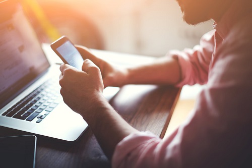 Image showing a man surfing on a smartphone to illustrate the social media marketing service offered by Fullframe creative agency studio in Lausanne and Geneva, Switzerland for the purposes of creative communication.